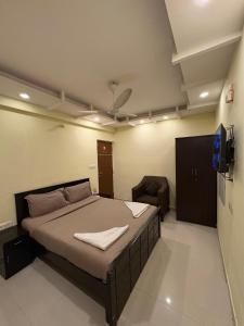 a bedroom with a bed and a television in it at Restora Amaze Inn in Bangalore