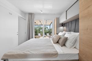 a bedroom with a large bed with white sheets and pillows at Olive Spa Oasis with Private Jacuzzi and Summer Kitchen in Orasac +92 photos