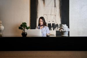 a woman sitting at a table with a laptop computer at Elysee Beach Hotel in Alanya