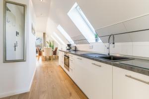 a kitchen with white cabinets and a sink at Himmelreich in Westerland