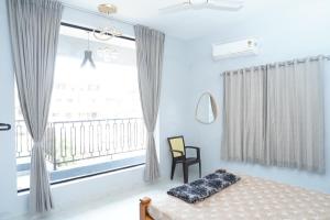 a bedroom with a bed and a large window at Sukruthi service apartment 3BHK in Mangalore