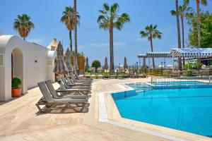 a row of lounge chairs next to a swimming pool at Elysee Beach Hotel in Alanya