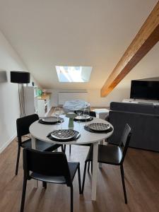 a living room with a table and chairs and a couch at Le Pompidou Clim - Parking - Terrasse - Centre in Albi +16 photos