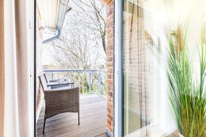 an open door to a balcony with a chair at Himmelreich in Westerland