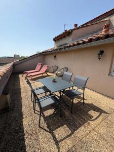 a patio with a table and chairs on a roof at Le Pompidou Clim - Parking - Terrasse - Centre in Albi
