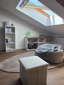 a living room with a skylight and a bed and a stool at Le Pompidou Clim - Parking - Terrasse - Centre in Albi