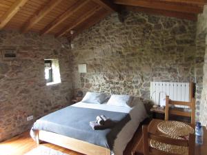 a bedroom with a bed in a stone wall at Casa Rústica, perto do Castelo de Óbidos in Óbidos