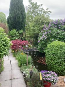a garden with a pond and many flowers at Ferienwohnung am Siel in Ditzum