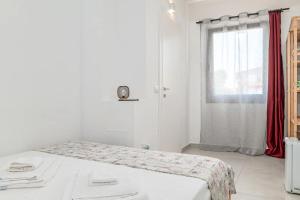a white room with a bed and a window at Ghjlgolu Suites - Essential Stay in Monte Petrosu