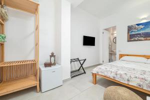 a bedroom with a bed and a tv on a wall at Ghjlgolu Suites - Essential Stay in Monte Petrosu
