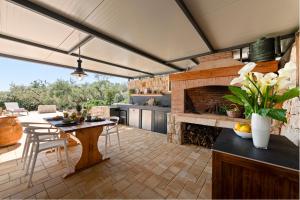 a kitchen with a table and a fireplace at Olive Spa Oasis with Private Jacuzzi and Summer Kitchen in Orasac