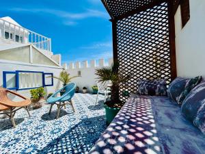 a patio with a couch and chairs on a patio at Riad Dar Abi in Essaouira