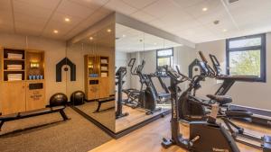 a gym with treadmills and exercise bikes in a room at Campanile PRIME - Le Blanc Mesnil in Le Blanc-Mesnil