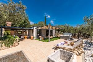 an outdoor patio with a table and chairs at Olive Spa Oasis with Private Jacuzzi and Summer Kitchen in Orasac