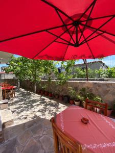 a red umbrella over a table on a patio at Guesthouse SELI in Berat