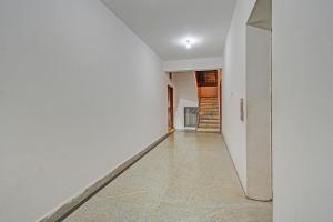 an empty hallway with white walls and tile floors at FabHotel Sun Mint - Jubilee Hills in Hyderabad