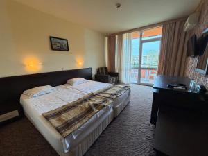 a hotel room with a bed and a large window at Hotel Amaris in Sunny Beach