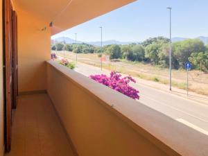 a balcony with purple flowers and a road at Magic DaLu House in Olbia