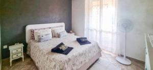 a bedroom with a bed with pillows and a fan at Magic DaLu House in Olbia