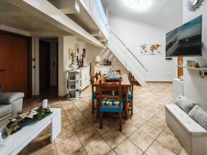 a living room with a table and a kitchen at Magic DaLu House in Olbia