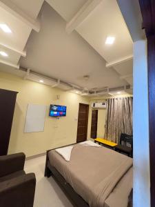 a bedroom with a bed and a tv on the wall at Restora Amaze Inn in Bangalore +6 photos