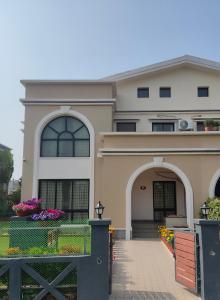 a house with a gate and flowers in front of it at Bhromor -A Pet-friendly Villa in Raichak