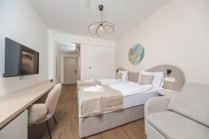 a hotel room with a bed and a couch at Garni Hotel MB Premium in Budva