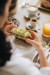a person holding a sandwich on a table at La Chipirona Hotel in Valencia