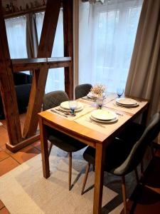 a wooden table with chairs and plates on it at Ferienwohnung Till in Mölln +5 photos