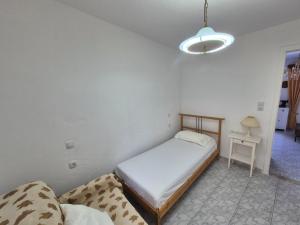 a bedroom with a bed and a table and a lamp at Dimitra House in Parga +2 photos