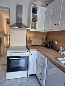 a kitchen with white cabinets and a stove top oven at Dimitra House in Parga