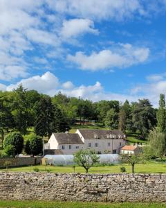 a house in a field with a stone wall at Domaine des Chailloux in Jully-lès-Buxy