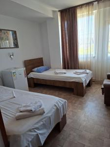 a hotel room with two beds and a window at Pensiunea Nicol Tulcea in Tulcea
