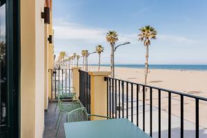 a balcony with a view of the beach and palm trees at La Chipirona Hotel in Valencia