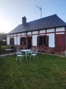a table and chairs in front of a building at Le clos du Souffle in Saint-Ouen-sous-Bailly