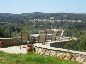 a patio with chairs and a table on a hill at Corfu Green Escape in Achílleion +10 photos