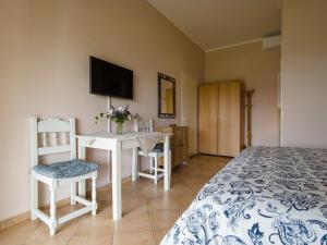 a bedroom with a bed and a desk and a television at Corfu Green Escape in Achílleion