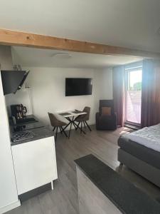 a living room with a bed a table and a kitchen at Haus Dani in Oldenburg in Holstein