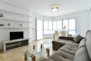 a living room with a couch and a tv at Gala Centro Modern I in Torrevieja