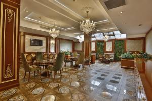 a dining room with tables and chairs and chandeliers at Alermo Hotel-SPA in Baku