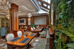 a restaurant with wooden tables and chairs and plants at Alermo Hotel-SPA in Baku