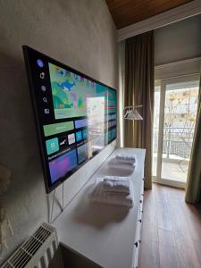 a room with a large screen tv on a wall at Sherlock Home in Komotini