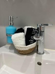 a bathroom sink with a basket of towels and a faucet at Amalize Luxury Apartments in Karistos