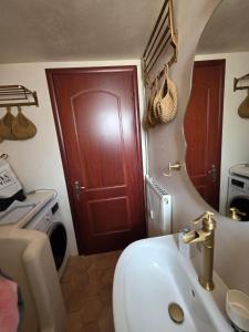 a bathroom with a sink and a wooden door at Sherlock Home in Komotini +41 photos