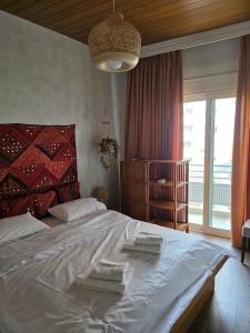 a bedroom with a large bed with two towels on it at Sherlock Home in Komotini