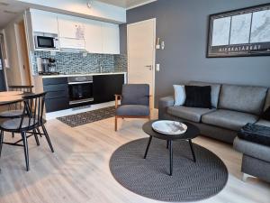 a living room with a couch and a table at Timantti Apartments by Hiekka Booking in Kalajoki
