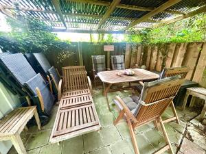 a patio with chairs and a wooden table and benches at Villa Topas in Wilhelmshaven