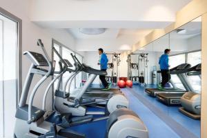 a gym with two men on treadmills in a gym at Royal Antibes - Luxury Hotel, Résidence, Beach & Spa in Antibes