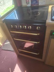 a black stove in a kitchen with a window at Park house farm caravan 2 in Richmond