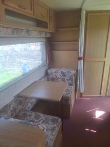 a small room with a table and a window at Park house farm caravan 2 in Richmond